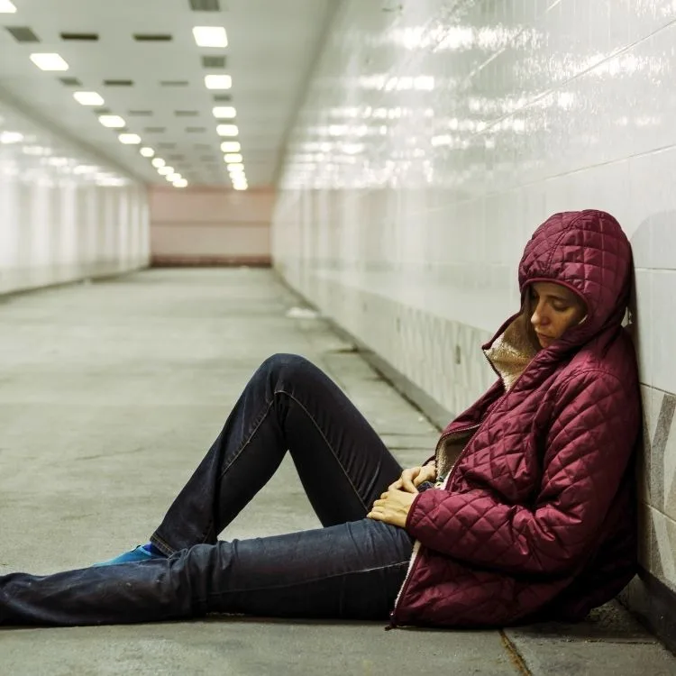 Woman lying on the floor in a subway tunnel